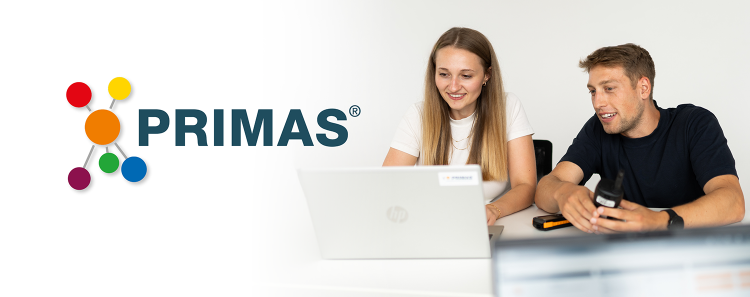 Test equipment management with PRIMAS A woman and a man are looking at a laptop; in the foreground, a man can be seen in profile.