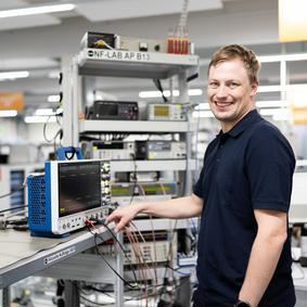 Calibration of electrical measuring instruments A man in a laboratory calibrates an oscilloscope