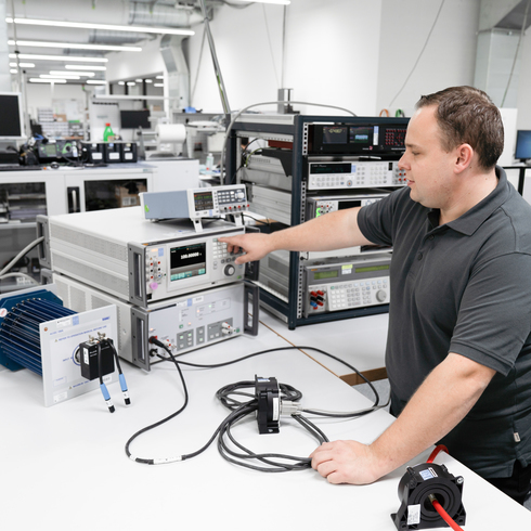 Calibration of low-frequency measuring instruments A man calibrates low-frequency measuring instruments in an electrical laboratory