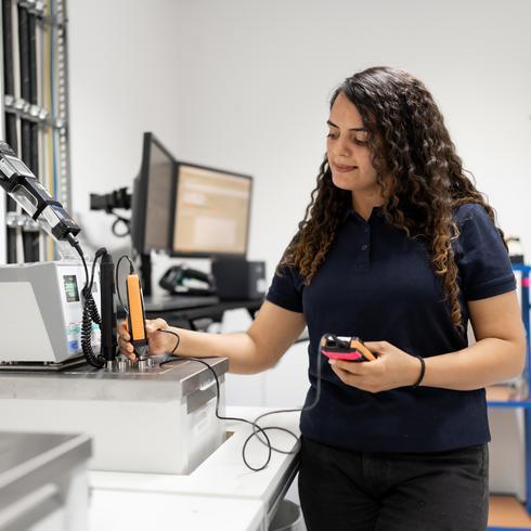 Calibration of temperature measuring devices A woman calibrates an immersion sensor in the temperature range in the laboratory