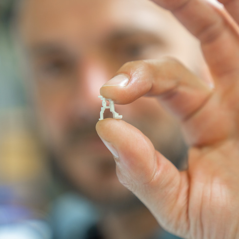 Industrial computed tomography Observation of a small workpiece in the hand of an employee