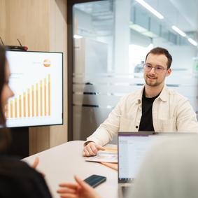 Mitarbeiter in einem Meeting mit Diagramm im Hintergrund